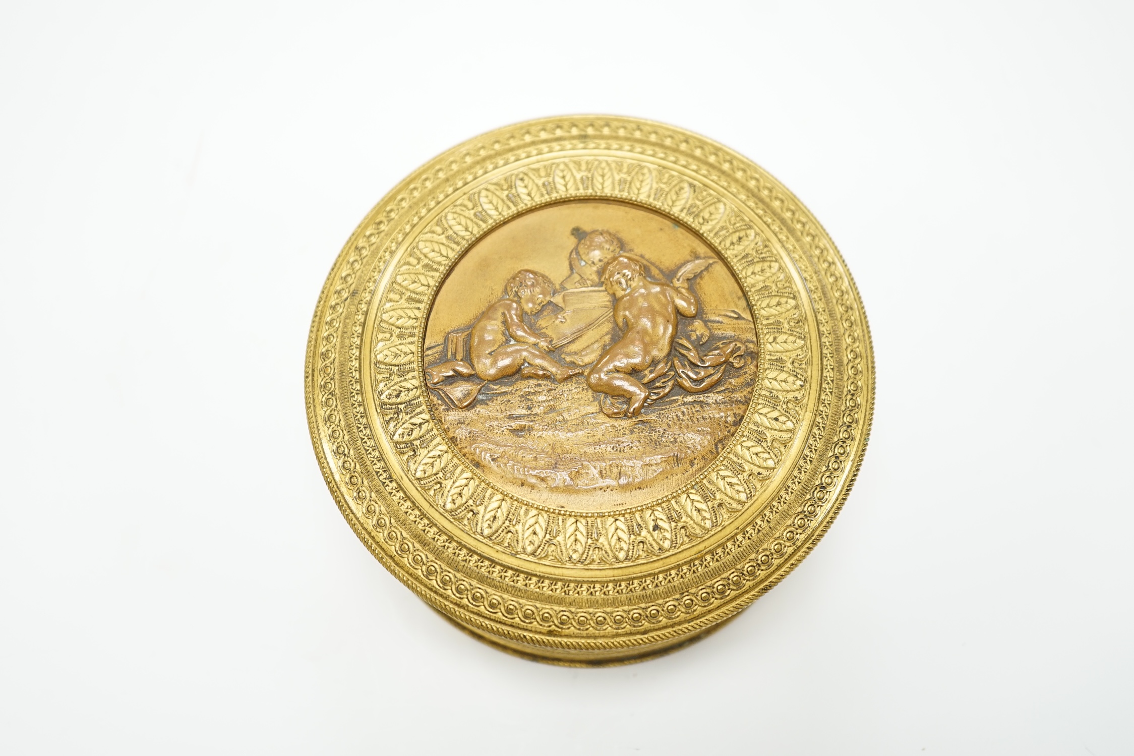 A 19th century French ormolu and bronze cylindrical box and cover with fitted mirror inside lid, 10cm diameter
